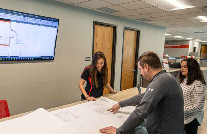 Group of employees studying plans in a collaboration area in the office