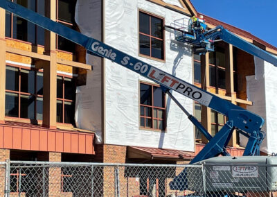 Construction at the Aurora West Bend facility featuring lift vehicles and a Beeler employee