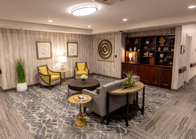 Sophisticated lounge space at Avalon Square featuring coffee table, chairs, couch and large book shelf with cabinetry