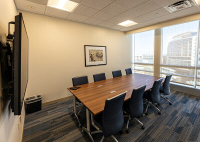 Mid-sided meeting room space at Children's Wisconsin Boardroom Renovation featuring tables, chairs, TV, and large picture windows