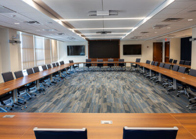 Children's Wisconsin Boardroom Renovation featuring long tables, rolling chairs, and multiple TVs