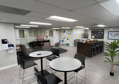 Lounge space featuring chairs, small, round high tables, and high-end Connect Four game from Eastcastle Place senior living facility