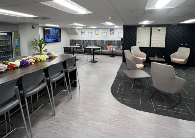 Sophisticated lounge space featuring chairs, tables, and TV from Eastcastle Place senior living facility