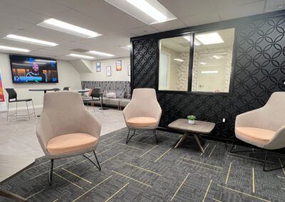 Sophisticated lounge space featuring chairs, end table, TV, and couch from Eastcastle Place senior living facility