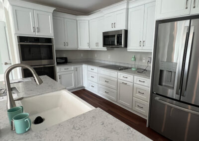 Kitchen space featuring sink, shelving, microwave, refrigerator, oven, and stove top from Eastcastle Place senior living facility