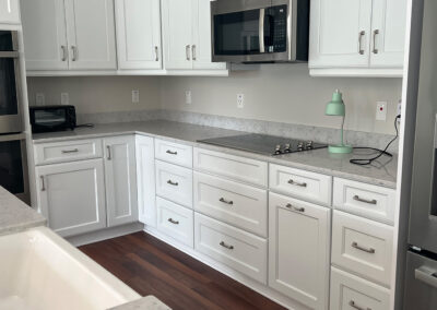 Kitchen space featuring shelving, microwave, and stove top from Eastcastle Place senior living facility