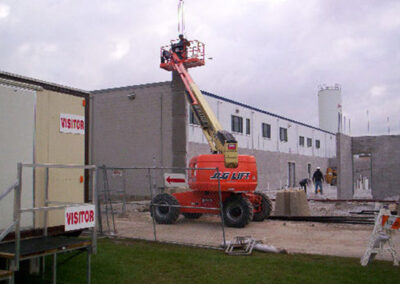 Exterior shot of the Henkel Surface Technologies building featuring a Beeler construction vehicle and employees