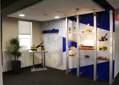 Komatsu feature wall with shelving and models of various construction vehicles