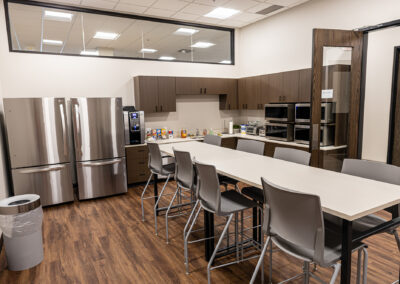 Kitchen area featuring cabinets, two refrigerators, long table, chairs, and microwaves at Westbrook MTE Tenant Buildout