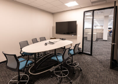 Meeting room at Westbrook MTE Tenant Buildout featuring mobile chairs, table, and TV